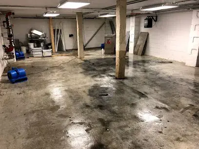 Air mover drying a wet concrete basement floor