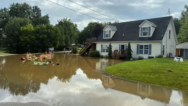 Storm water flooding the street and front yard of a suburban Michigan home