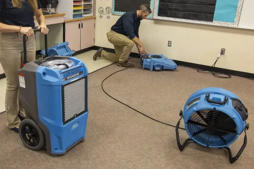 Air movers and an LGR dehumidifier drying a room after a water loss